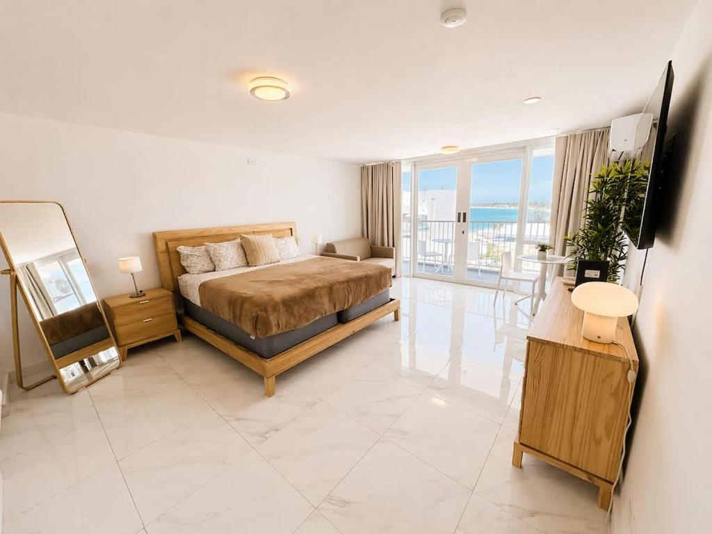 a bedroom with a bed and a view of the ocean at Oceanview Beach Condo in Prime Location in San Juan