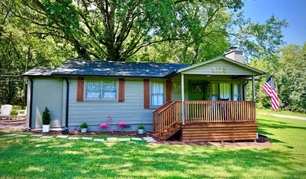 a small house with a porch and a flag at Kitschy Kottage in Expansion