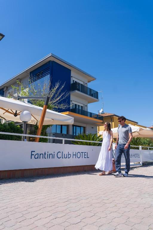 a man and a woman standing in front of a hotel at Fantini Club Hotel in Cervia