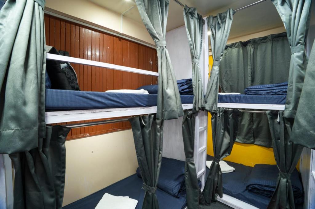 a room with three bunk beds on a boat at Dixit Homestaay & Hostel in Darjeeling