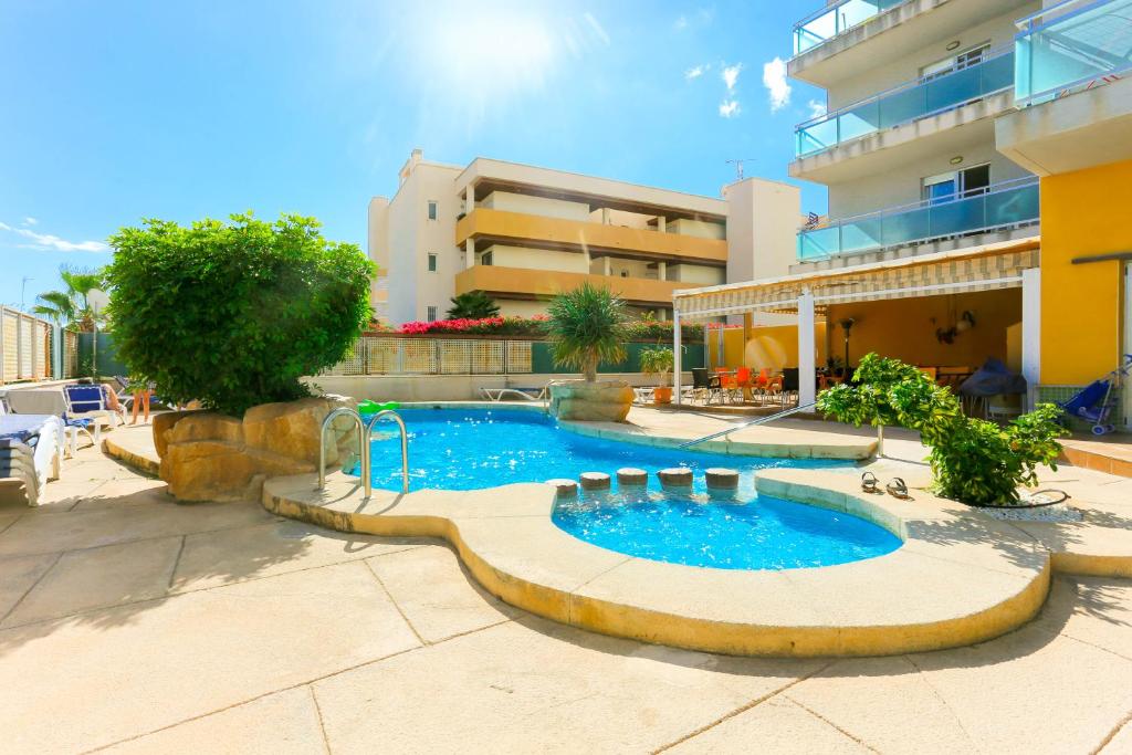 a swimming pool in front of a building at Elsa's Rotonda Apartment in Cabo Roig