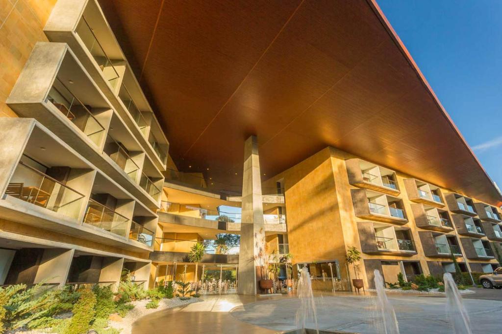 a large building with a fountain in front of it at Rioverde Living suites- Apartahotel in Rionegro