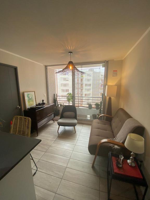 a living room with a couch and a window at Exponor 2026 DEPARTAMENTO 1 DORMITORIO in Antofagasta