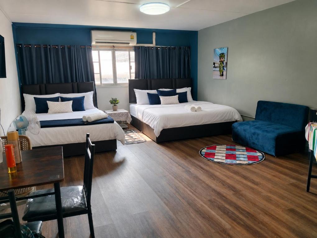 a living room with two beds and a couch at popular condo c5 แม่ตัง in Thung Si Kan
