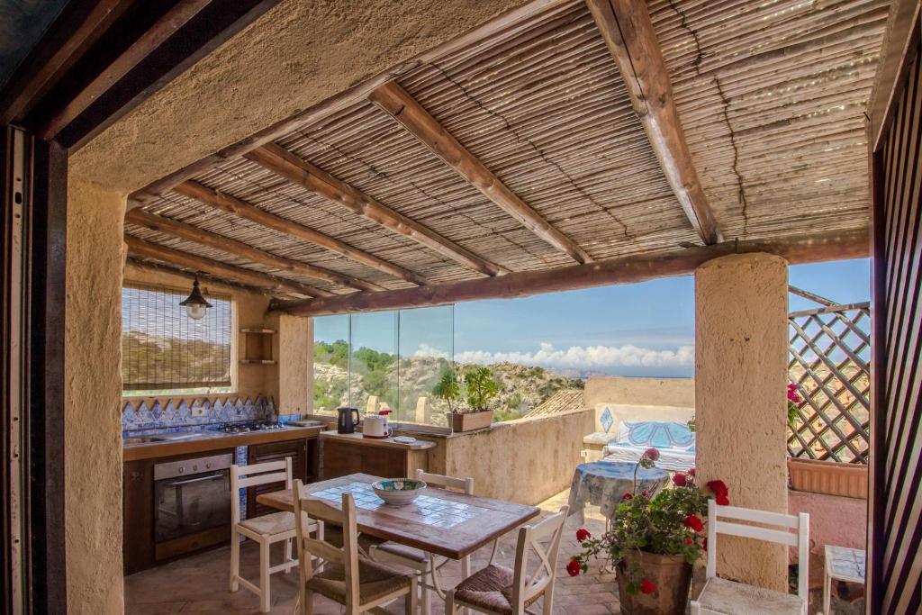 a kitchen and dining room with a view of the desert at GuestHost - Sea View Flat with Veranda and Pool in Liscia di Vacca