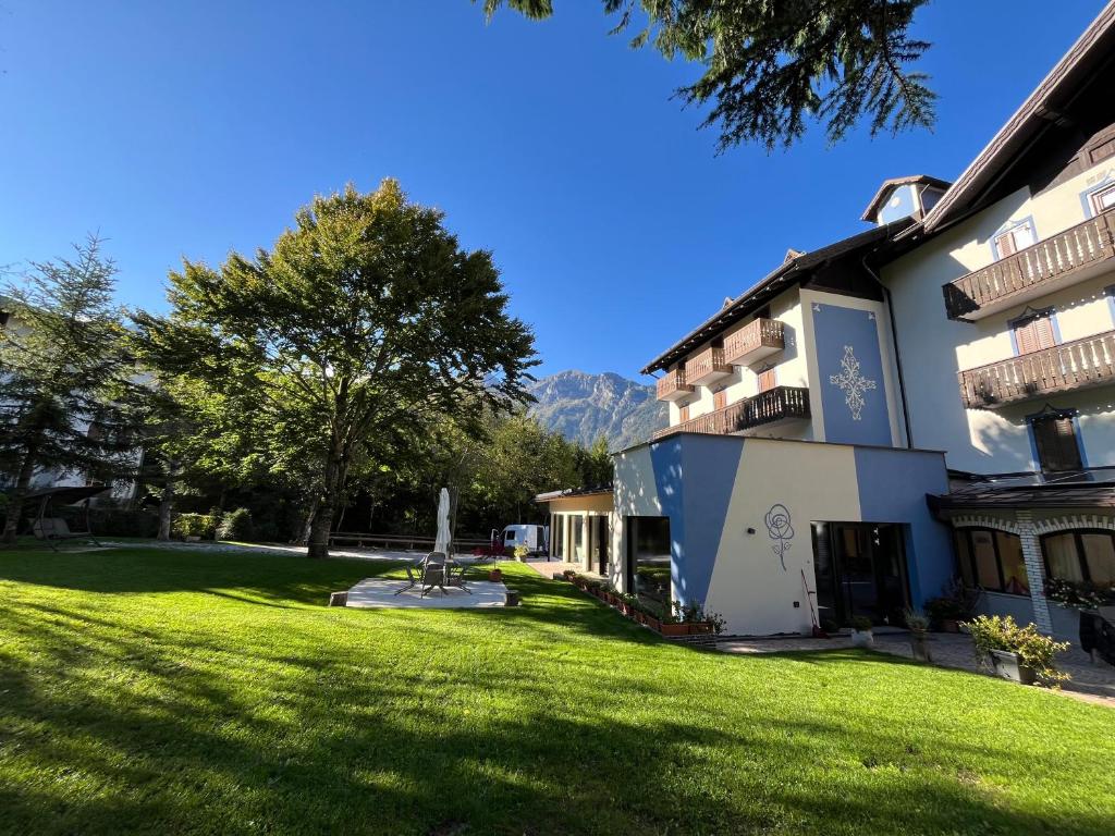 a building with a large yard in front of it at Hotel alle Rose Family inspired garden and SPA in Cavedago