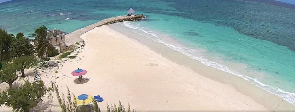 an overhead view of a beach with umbrellas and the ocean at 3BR Beachfront Villa w/ Staff-DRMNV in Duncans