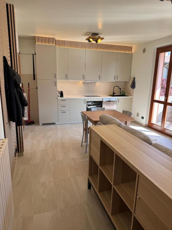 a kitchen with white cabinets and a wooden table at Casa Serena - Sarnico in Sarnico