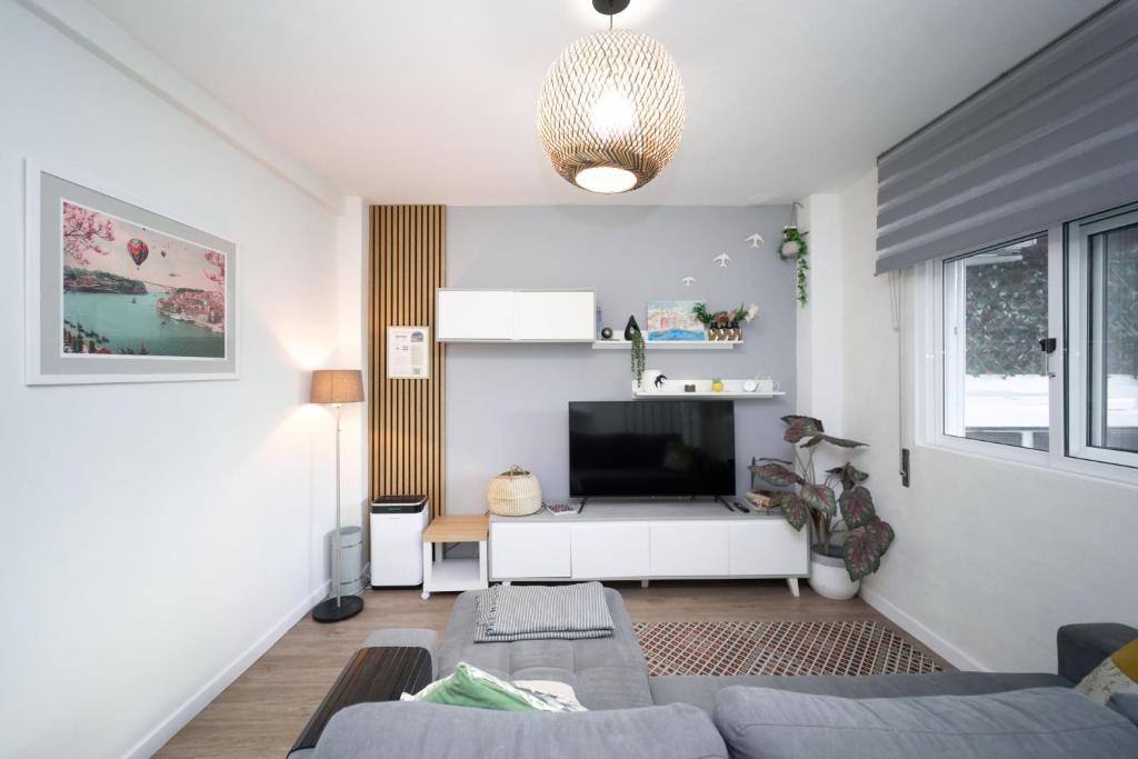 a living room with a couch and a tv at Refúgio do Pilar in Vila Nova de Gaia