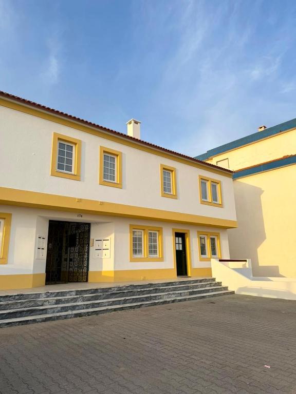 a large yellow building with steps in front of it at Baleal Beach Haven - Surf, Sun & Sea in Ferrel