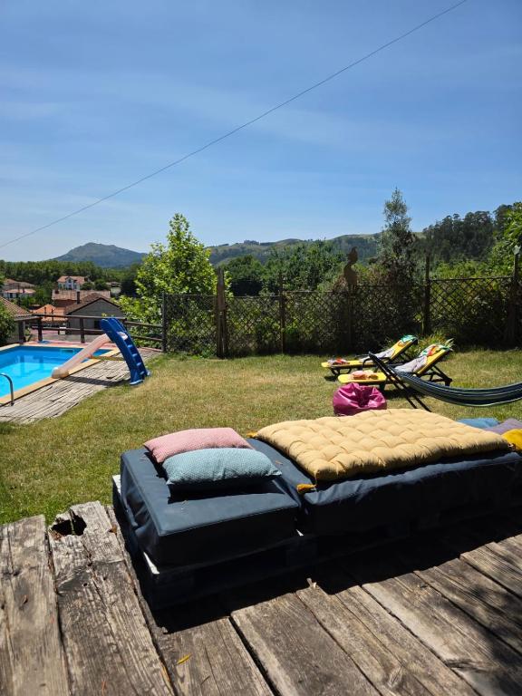 a bed on a wooden table next to a pool at Casa S. Nicolau in Cabeceiras de Basto