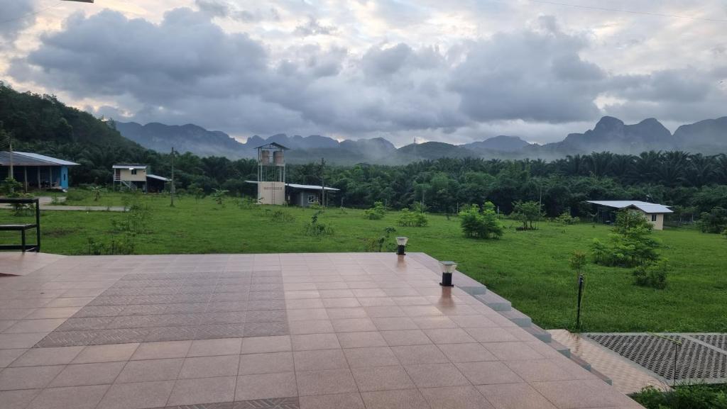 a patio with a view of a field and mountains at Boonfarm&homestay in Ban Nop Hak