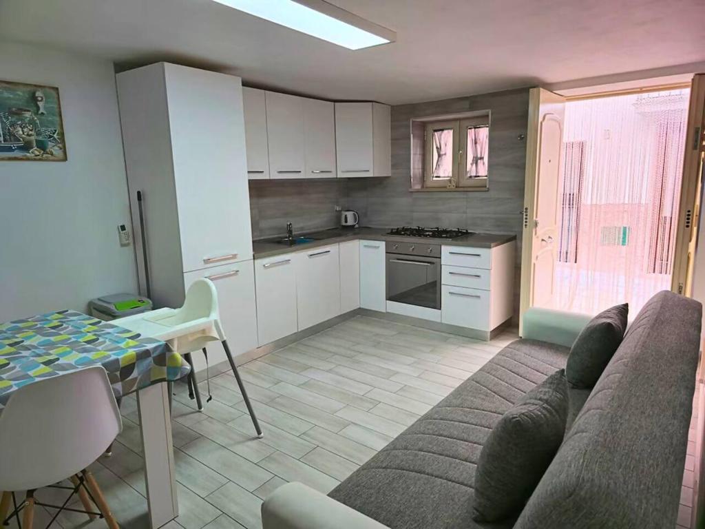 a living room with a couch and a table and a kitchen at TERRA HOME Gaeta - Moderno Bilocale nel Borgo in Gaeta