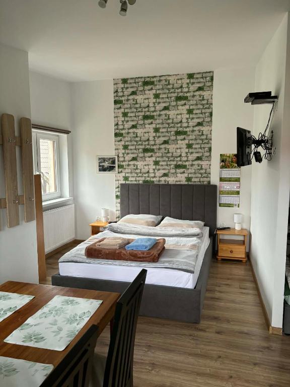a bedroom with a large bed and a table at Pokoje U Anny i Łukasza in Swornegacie