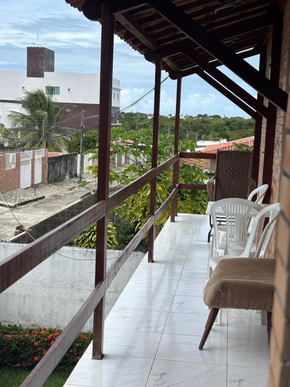 a balcony with chairs and a view of a city at Hotel pousada czar in João Pessoa
