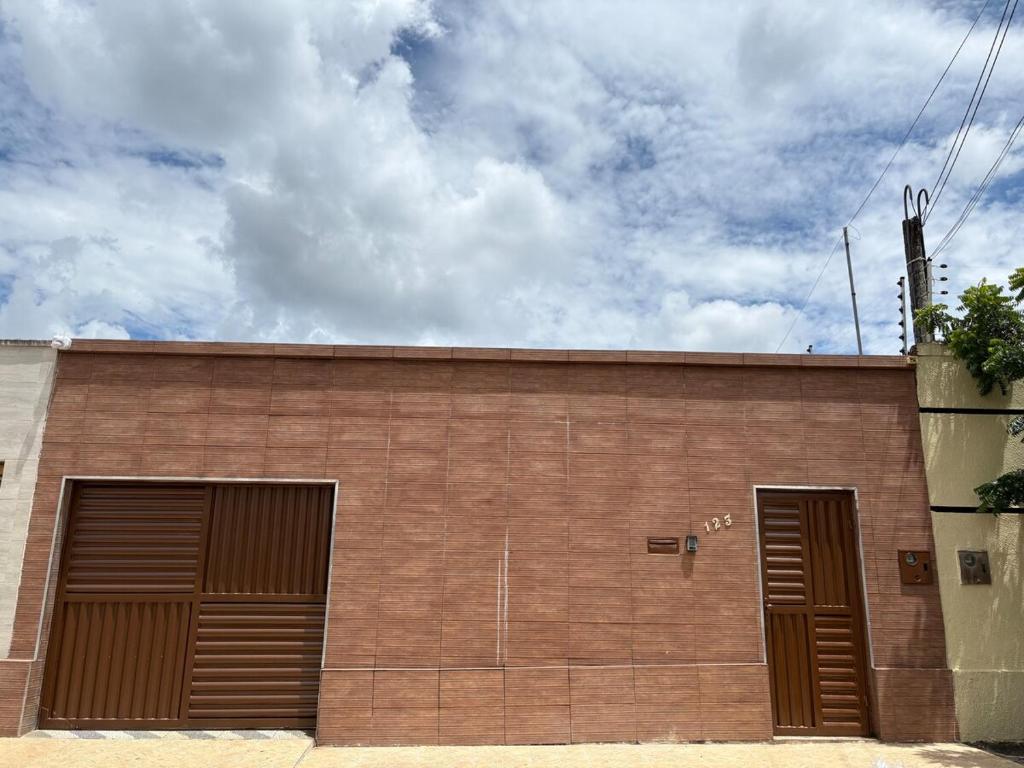 a brown brick building with two garage doors at Casa IBM - Crato in Crato