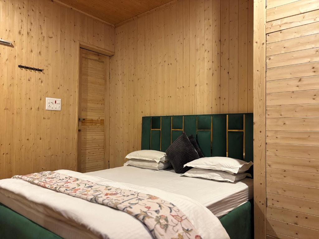 a bedroom with a bed with a green headboard at Favela Headrooms in Srinagar