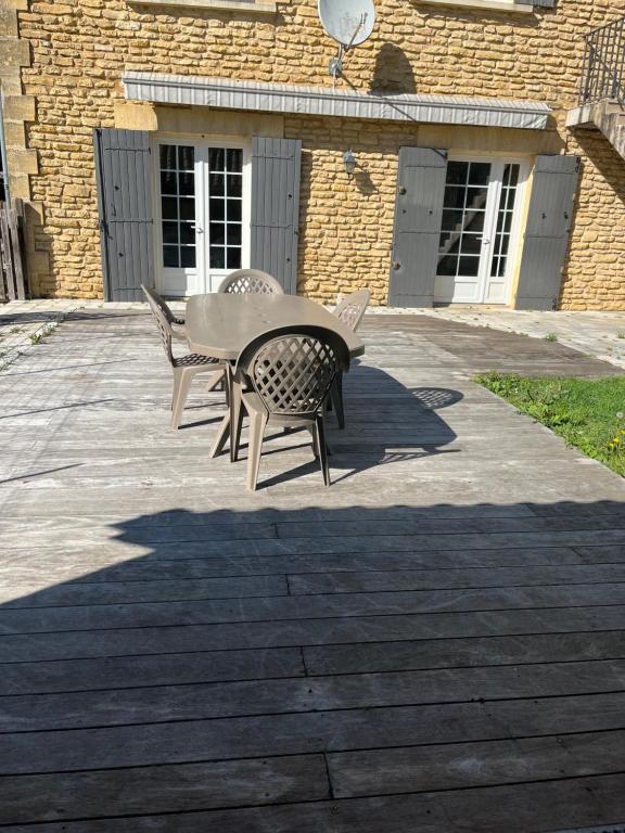 a table and chairs sitting in front of a building at Le Petit Clos périgourdin in Église-Neuve-de-Vergt
