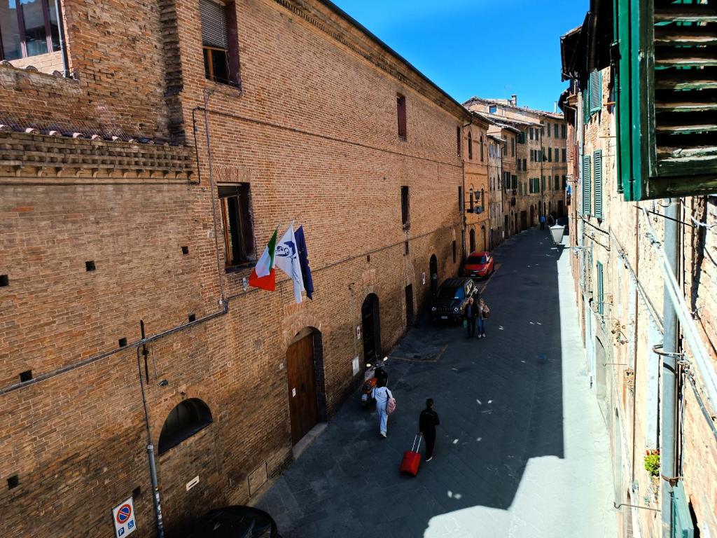 an alley with people walking down a street at Roveto Home in Siena