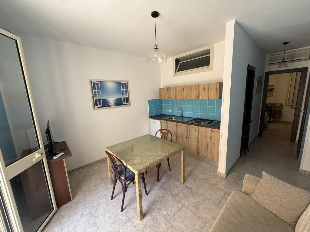 a living room with a table and a kitchen at Blue Home in Lampedusa