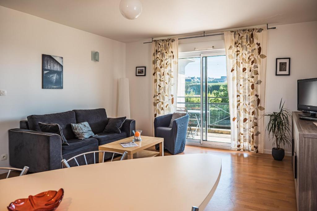 a living room with a couch and a table at Terrasse de l'aber Roscoff in Roscoff