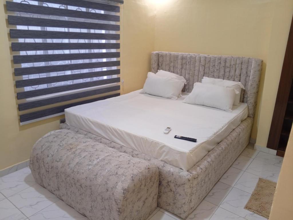 a bed in a room with a large mattress and pillows at Lovely surulere apartment in Lagos