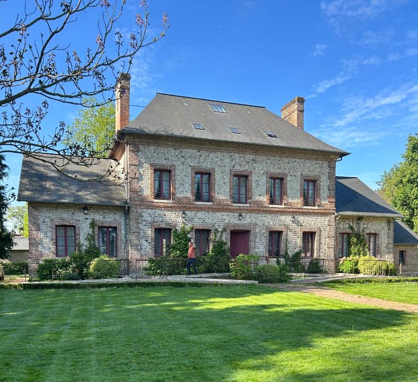 an old brick house with a large yard at Manoir de Daubeuf in Daubeuf-Serville