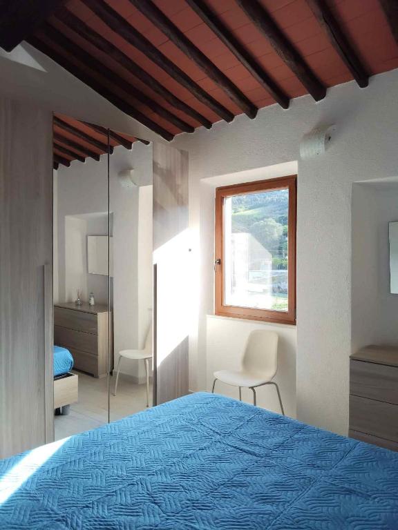 a bedroom with a blue bed and a window at Casa Peppo in Marciana