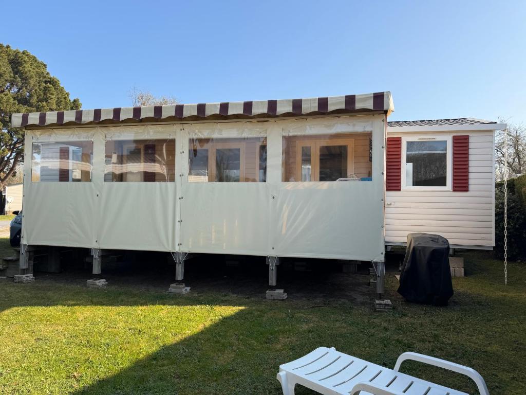 a white house with a porch and a bench at Camping les charmettes- in Les Mathes