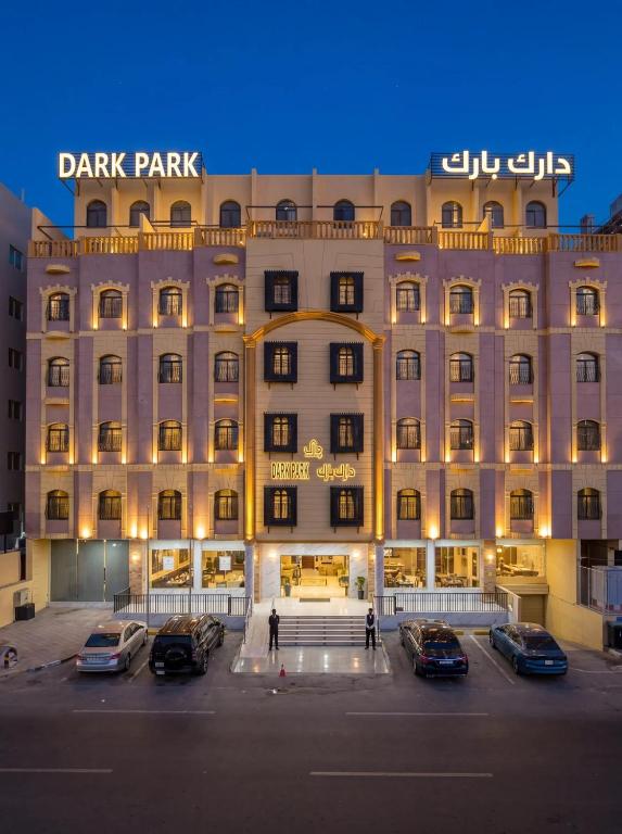 a large building with cars parked in a parking lot at فندق دارك بارك حي الشاطئ Darak Park Hotel Jeddah in Jeddah