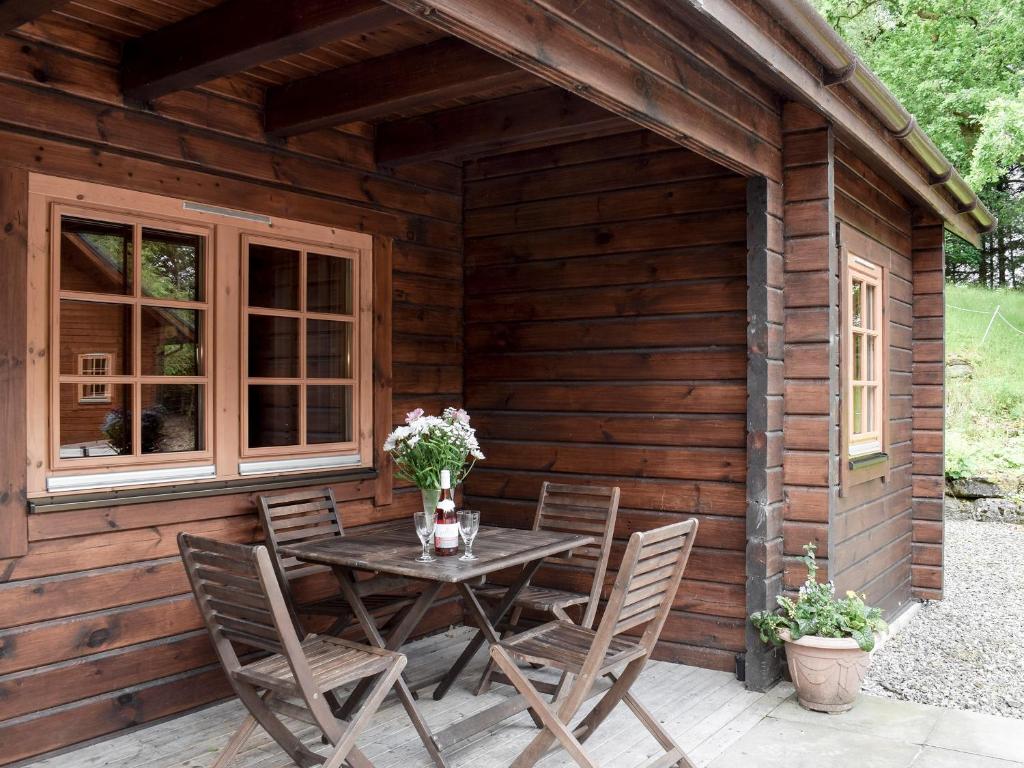 a table and chairs in front of a cabin at Alder - Uk5502 in Killin