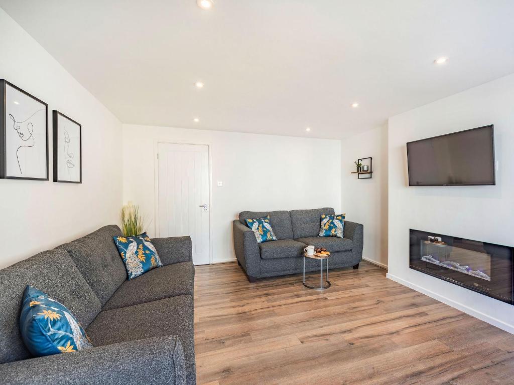 a living room with a couch and a flat screen tv at Hotspur View in Alnwick