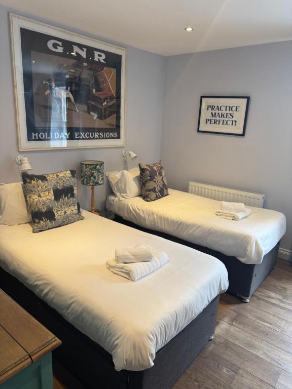 two twin beds in a room with a picture on the wall at Wheatsheaf Inn in Brigsteer