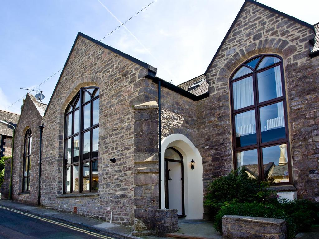 a brick house with large windows on a street at 3 Torwood Gables in Torquay