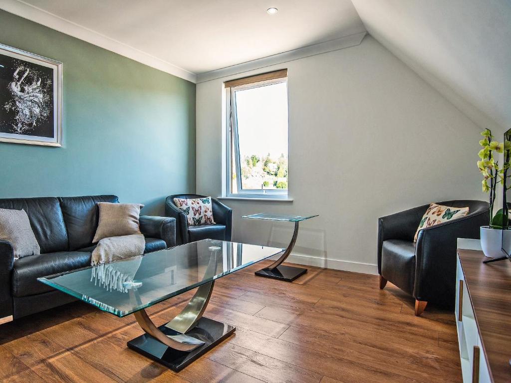 a living room with couches and a glass table at Tay Views Apartment in Perth