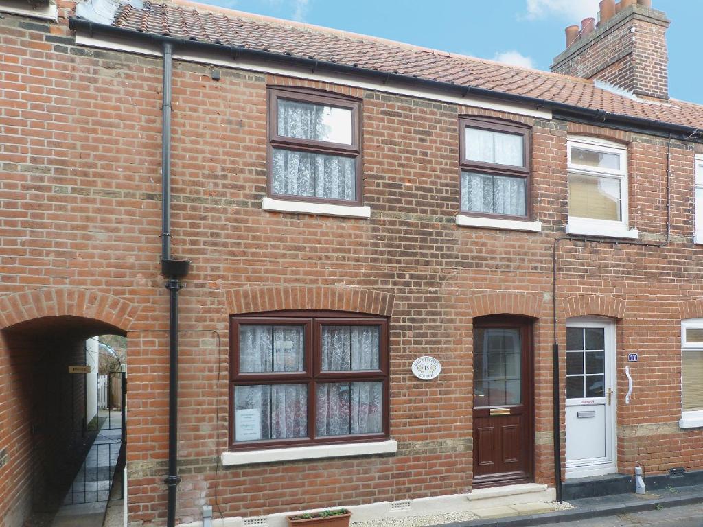 a red brick building with windows and a door at Watchkeeper's Cottage in Mundesley