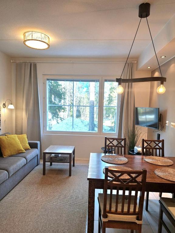 a living room with a table and a couch at Yllästar 3 - Cozy Stay in Magical Lapland in Äkäslompolo