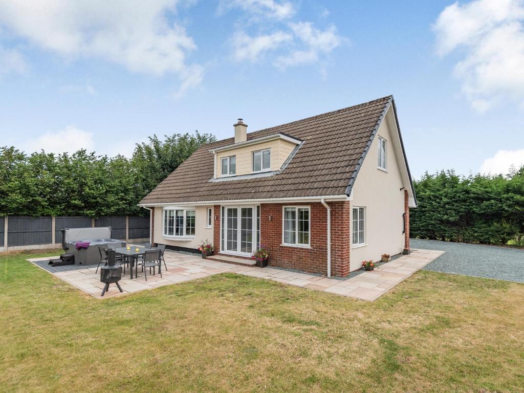 a house with a patio with a table and chairs at Pennant in Llanerfyl