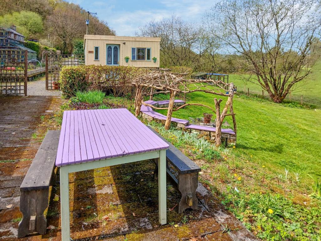 a purple picnic table in a yard with a house at Rosie - Uk49025 in Pencarreg