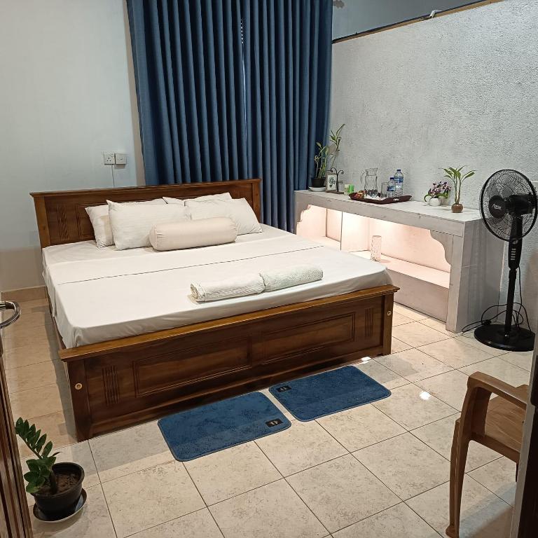 a bedroom with a large bed with white sheets at Pavani Villa Kandy in Peradeniya