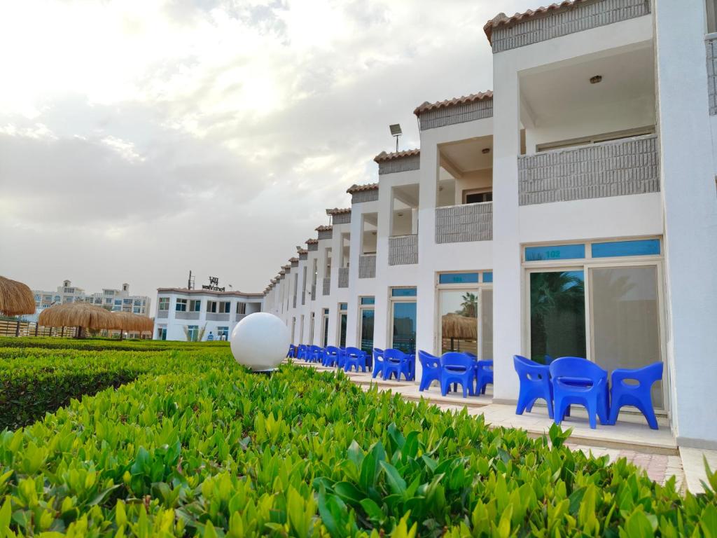 a building with blue chairs in front of it at Porto View in Hurghada