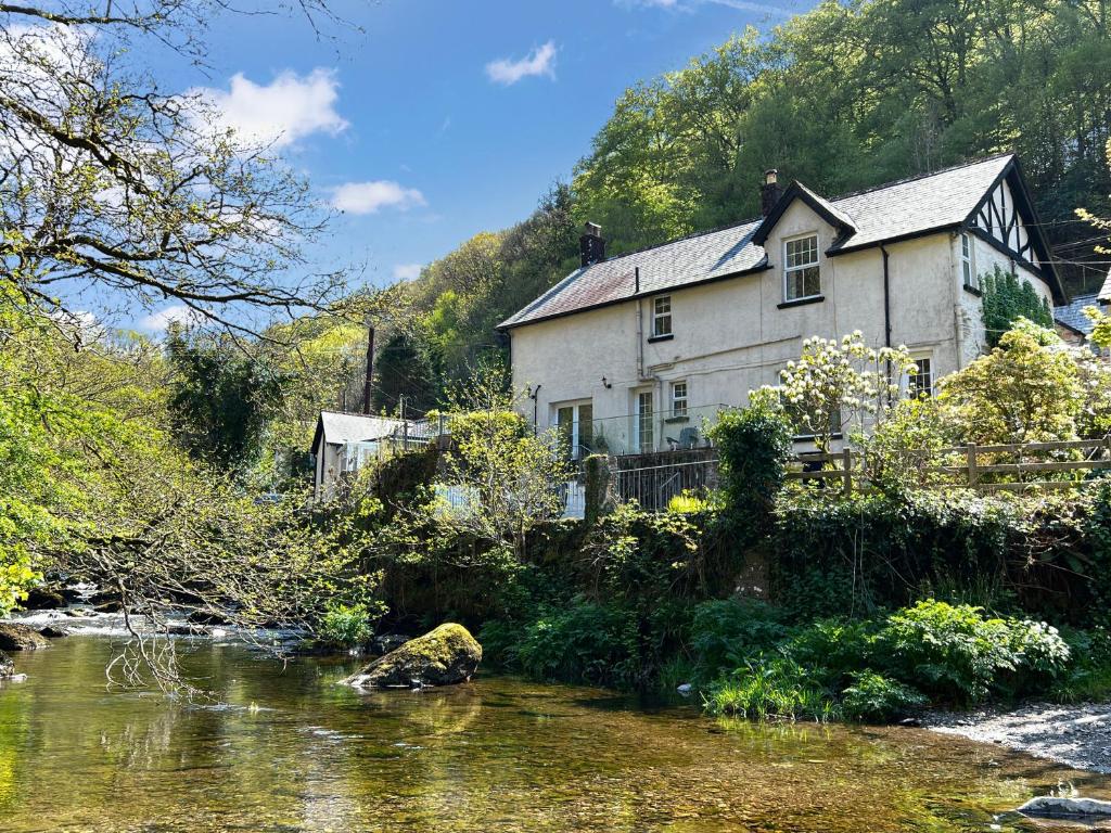 a house next to a river in front of a house at Rockford Cottage Brendon in Countisbury