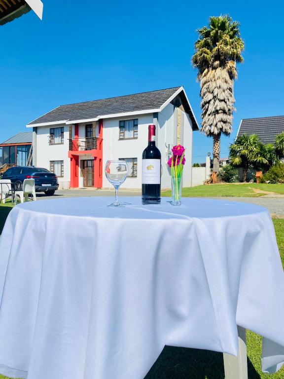 a table with a bottle of wine and two glasses at Phomolo Guest House in Maseru