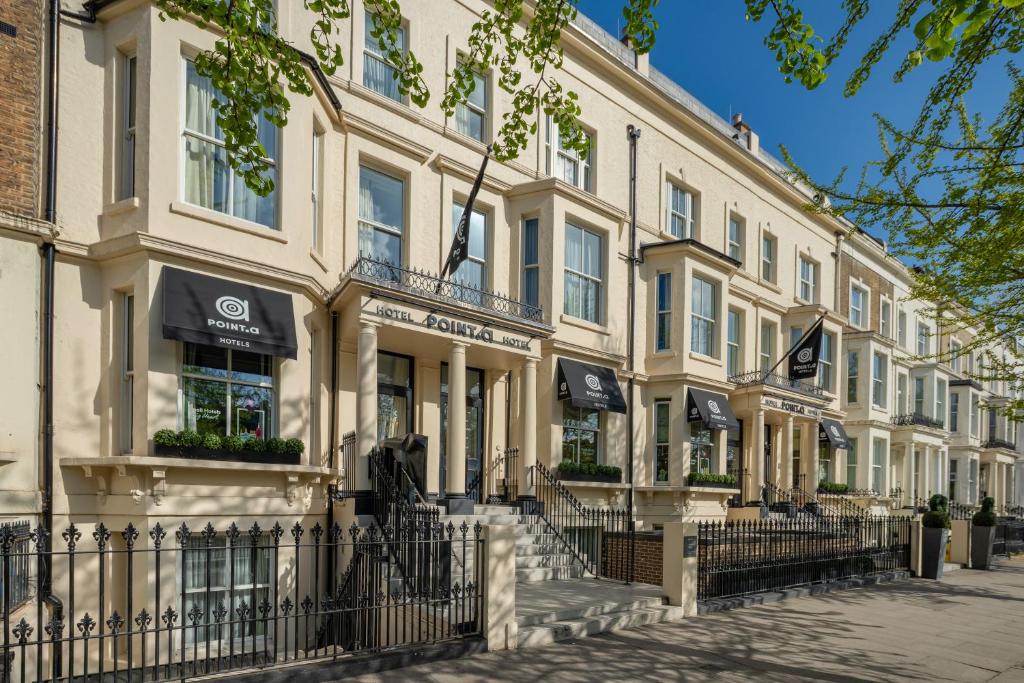 a row of white buildings on a street at Point A Kensington Olympia in London