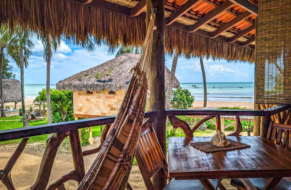 a hammock in a resort with a view of the beach at Pousada Lacula in Praia de Moitas