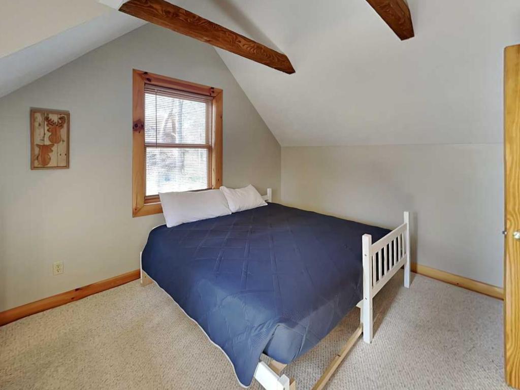 a bedroom with a blue bed in a attic at Duck Pond Lodge in McHenry