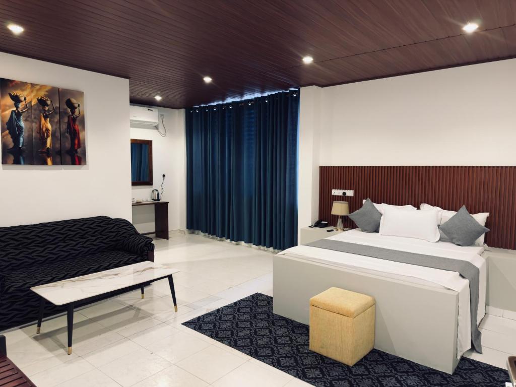 a bedroom with a king sized bed and a couch at New National in Pettah