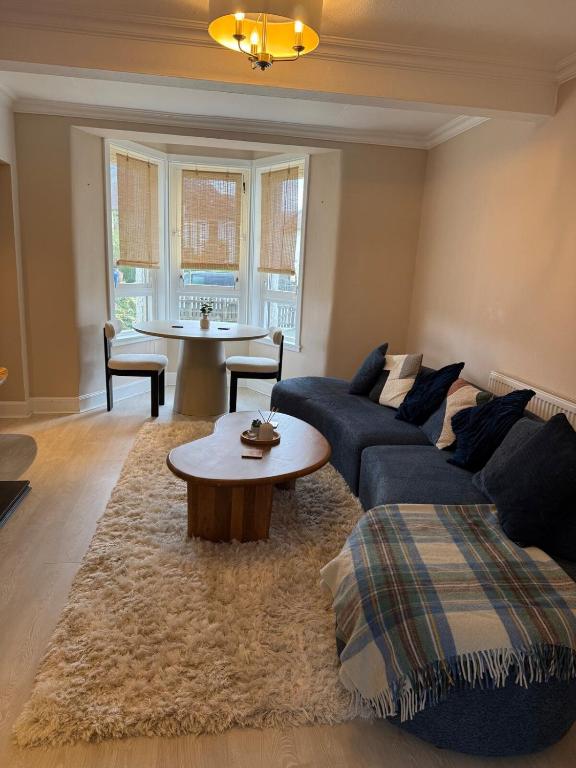 a living room with a couch and a table at 15 By The Shore in Caol