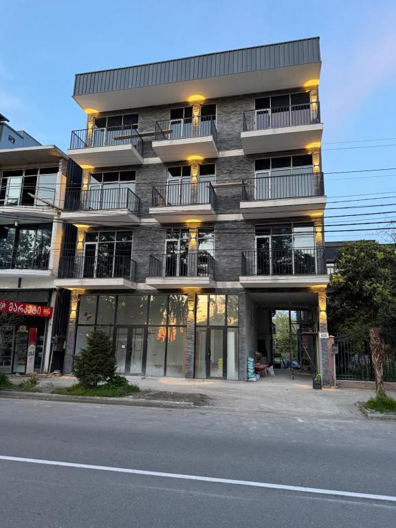 a tall building with windows and balconies on a street at Park Avenue Kobuleti in Kobuleti