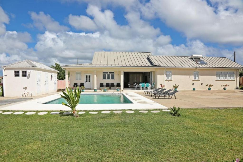a house with a swimming pool in the yard at Ocean View Villa with pool in Christ Church